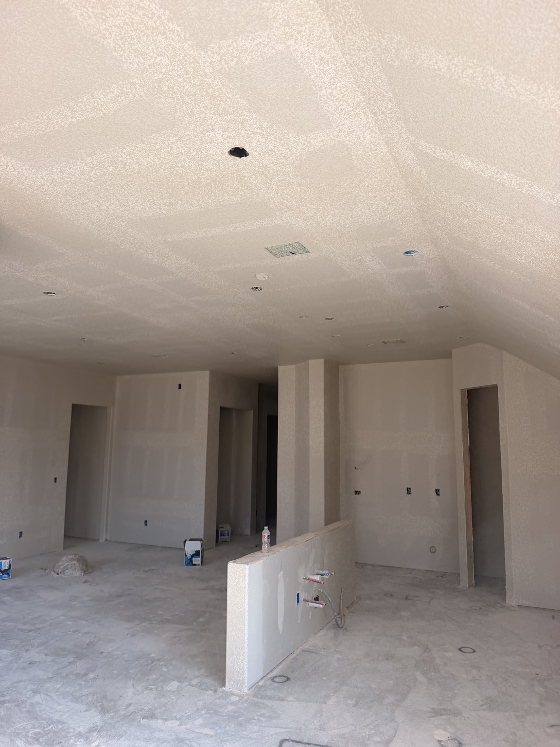 Residential living area with textured ceiling and drywall finishing